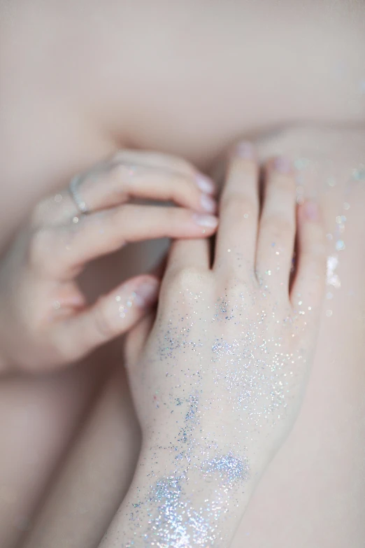 a person's arm has white glitter on it