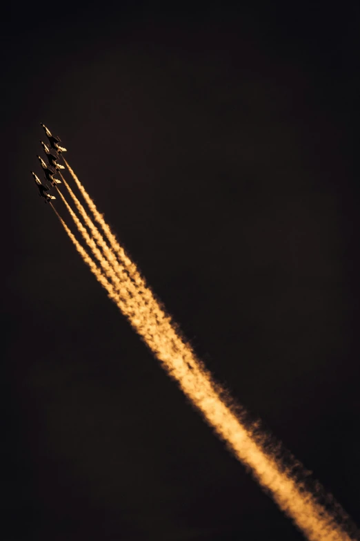 four planes flying in the night sky with trails