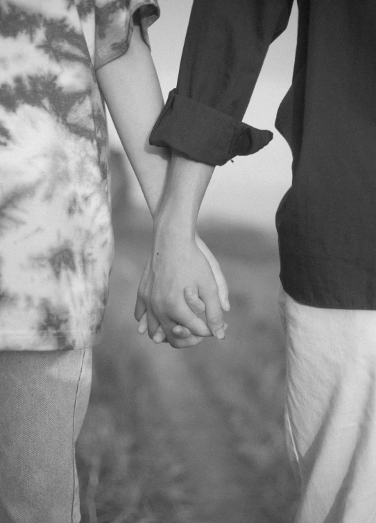 two people holding hands while standing next to each other