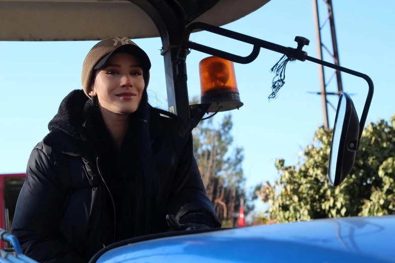 the woman stands inside a vehicle by a stoplight