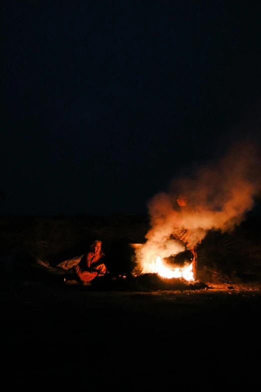 people sitting around a fire in the dark