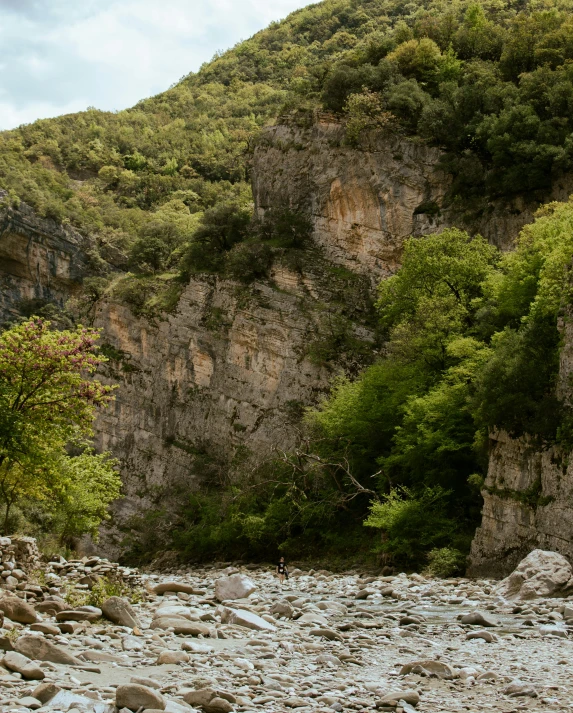 a rocky creek surrounded by a steep rocky cliff