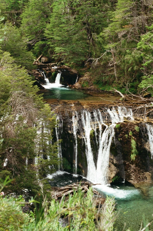 waterfall running down the side of a cliff with water coming out from its sides