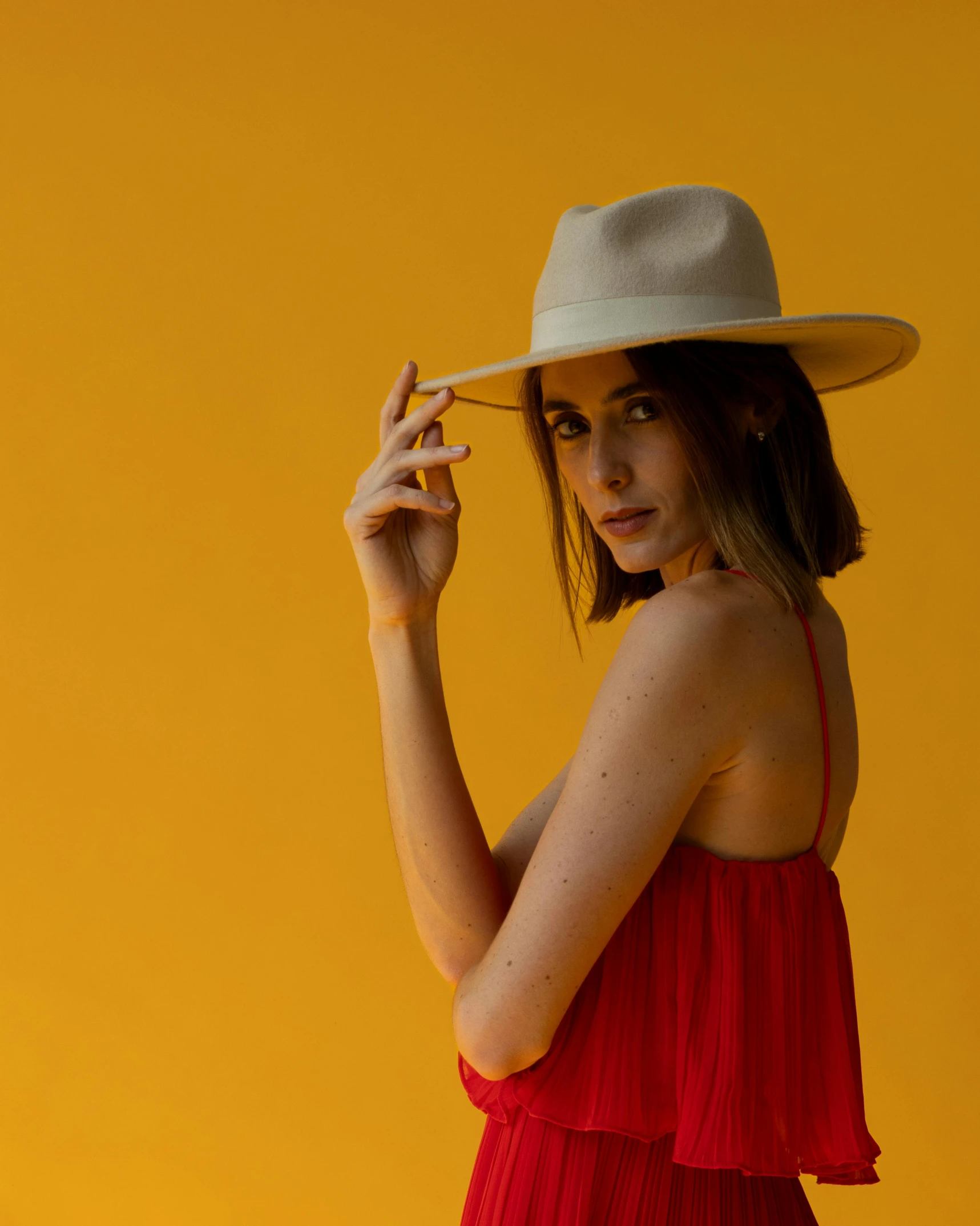 a woman is wearing a red dress and a hat