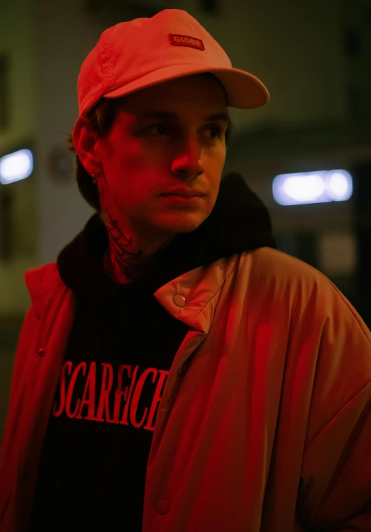 a young man wearing a pink baseball cap