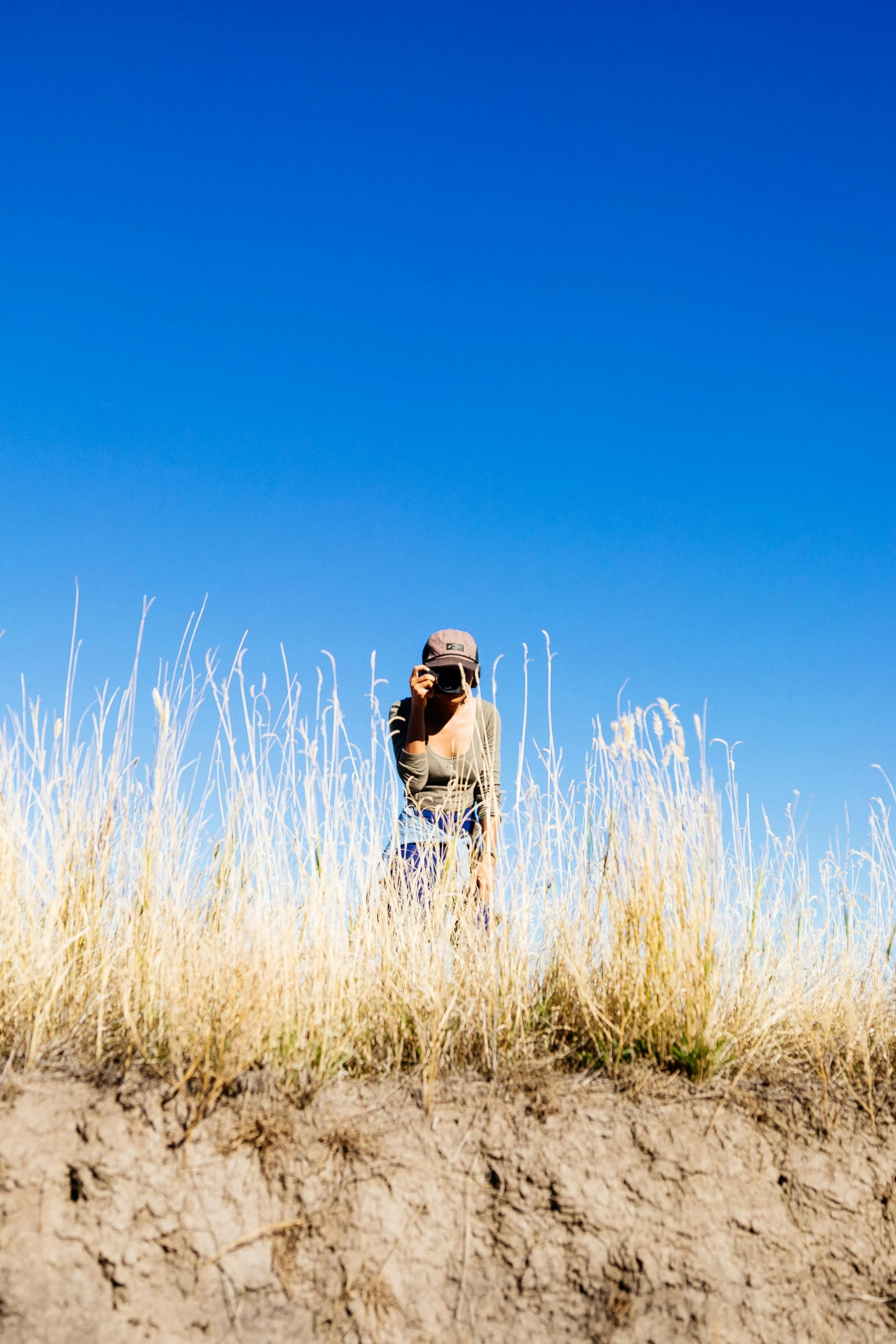 a man stands in the middle of tall grasses