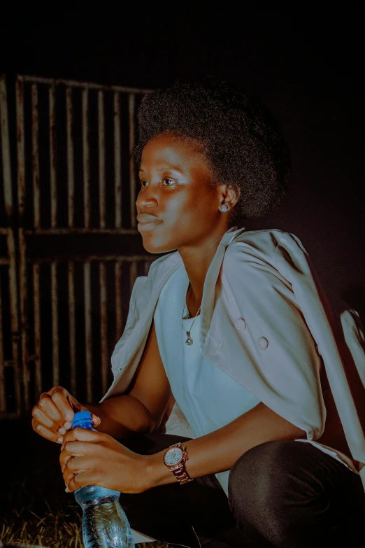 a woman holding a bottle of blue liquid