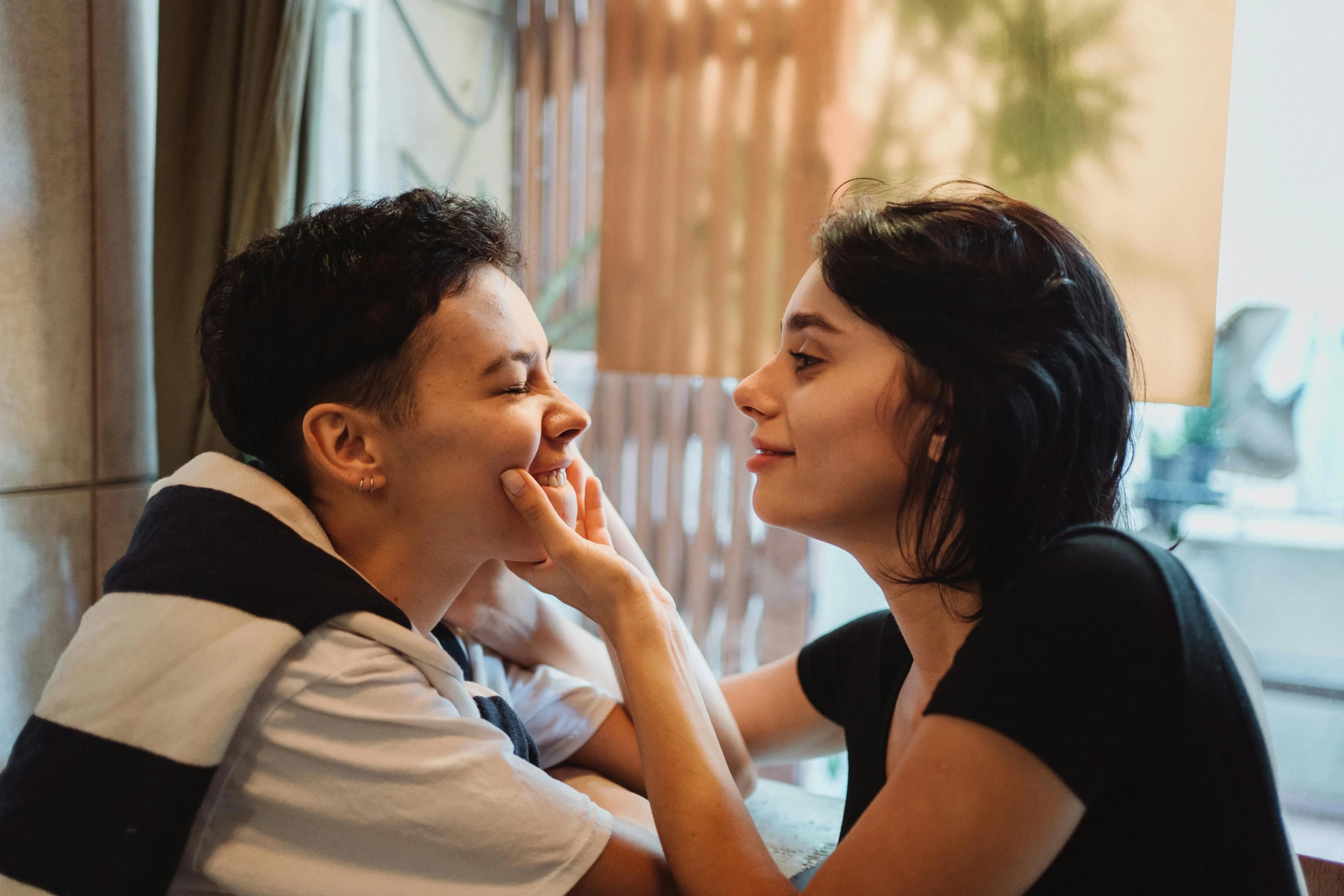 a couple is sitting together, looking into each others eyes