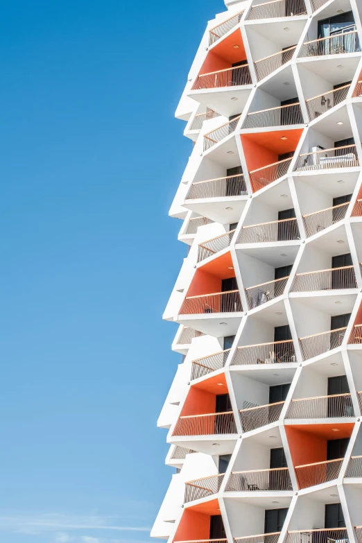 a tall white building with balconies and multiple floors