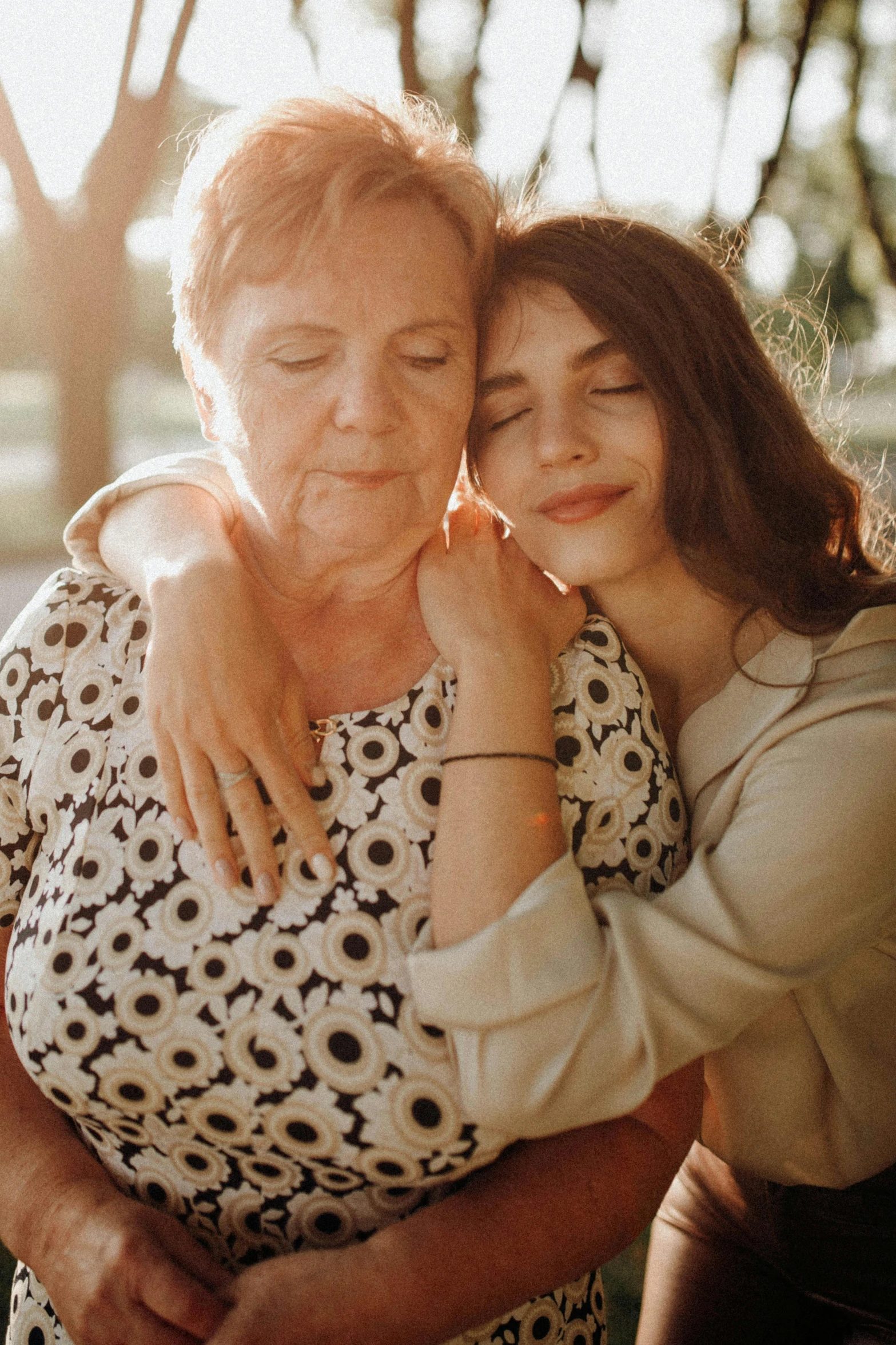 an older woman hugs another woman on the side of her face
