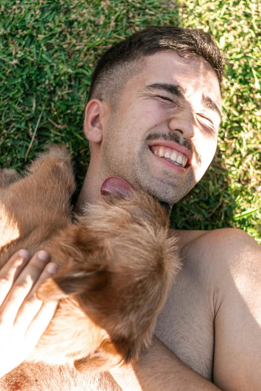 a man laying down and smiling with his dog