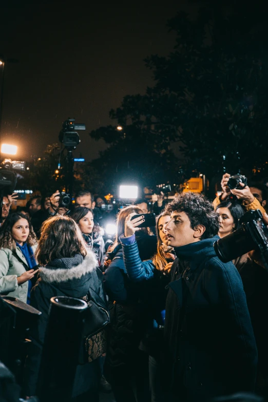 people taking pictures in a crowd at night