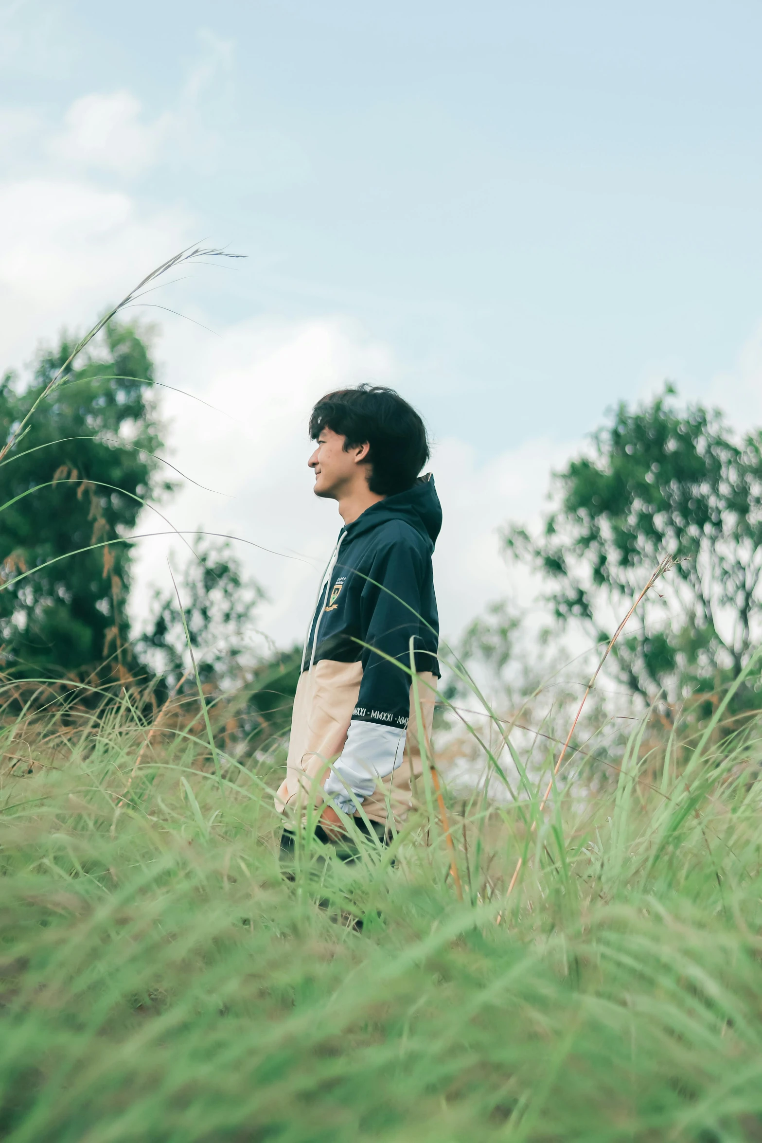 a man is standing on the side of a tall grass covered hill