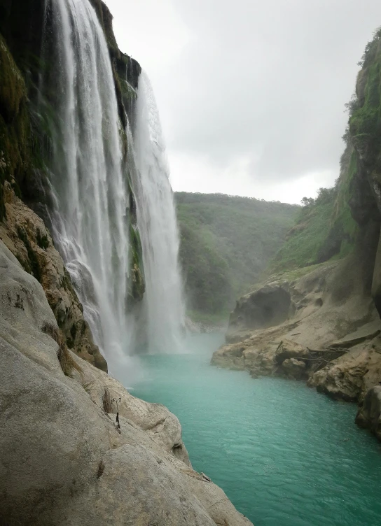 an alpine lake in front of a huge waterfall