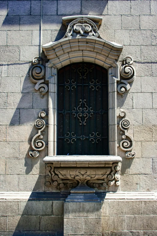 a decorative stone window with a small wrought iron gate