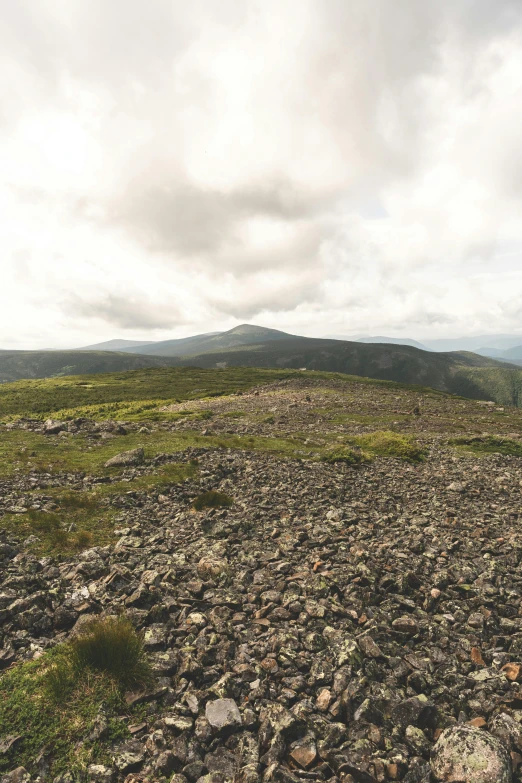 looking down on a hill that is surrounded by rocks and grass