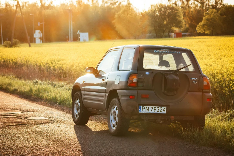 a small car sits in the middle of a gravel road