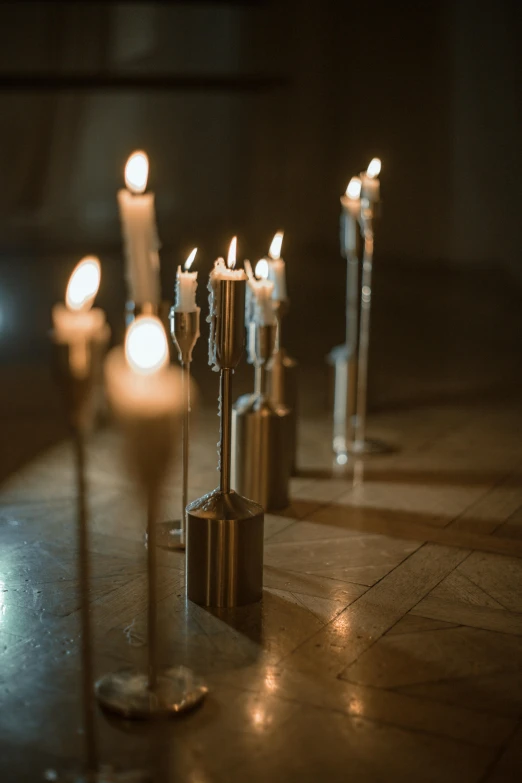 lit candles lined up in rows on the ground