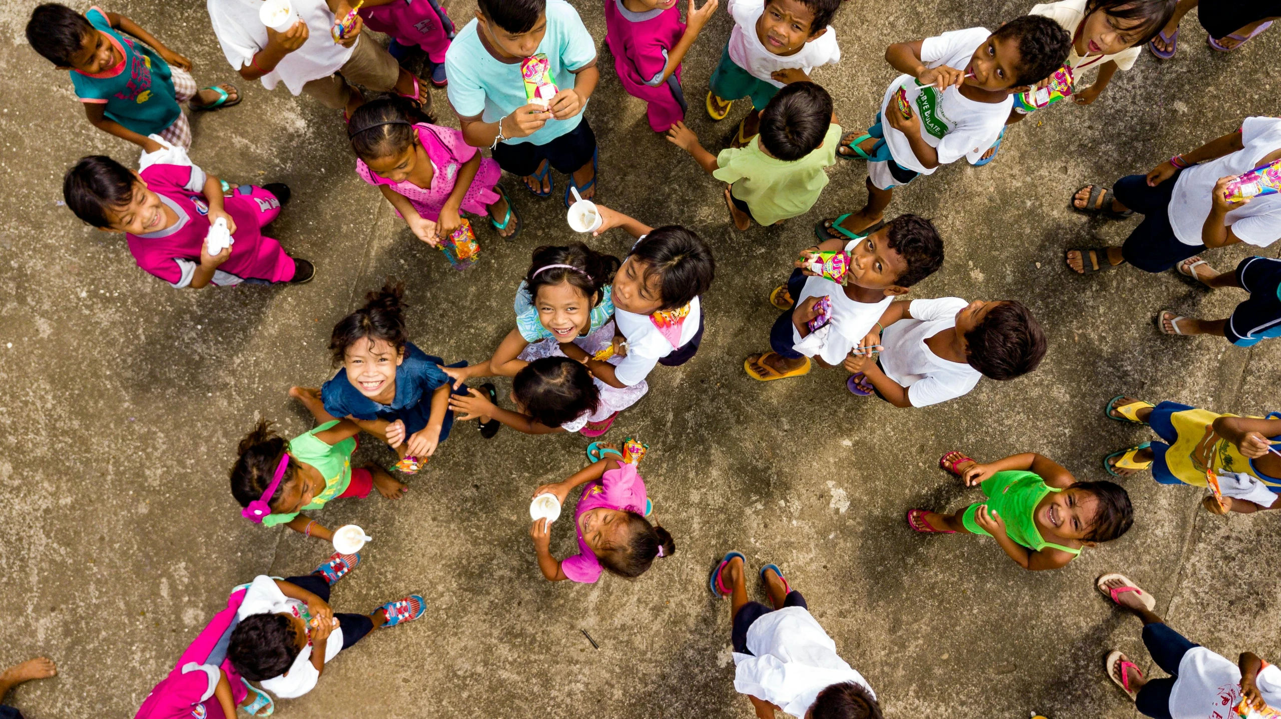 a group of children with one holding onto a kite