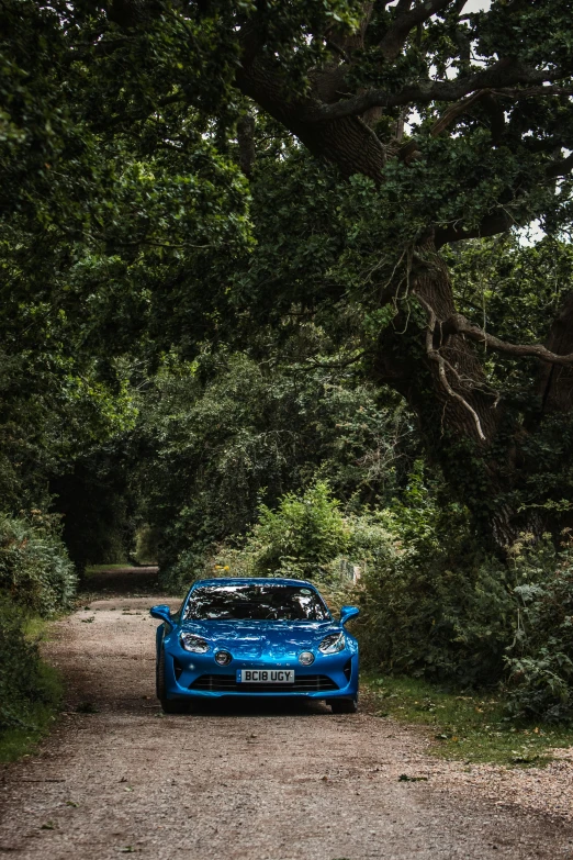 a car is parked on a gravel road in the woods