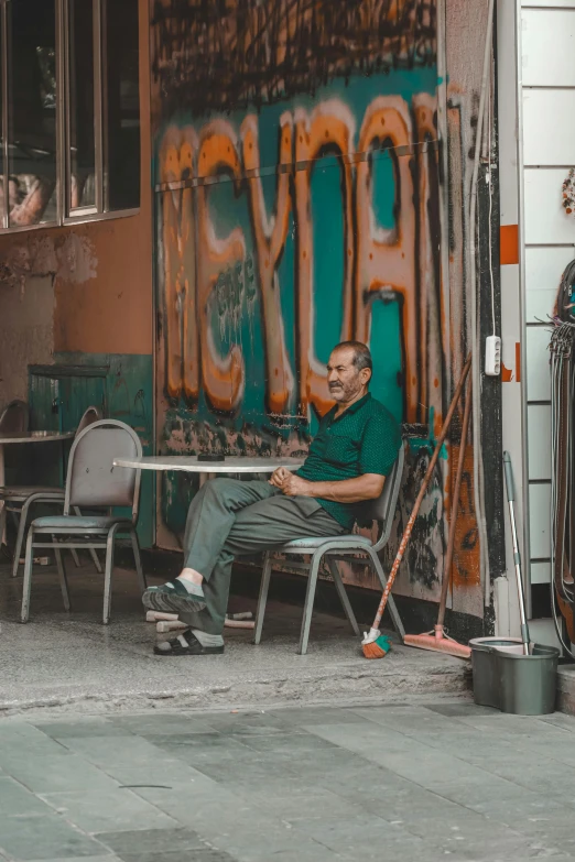 a man is sitting on a chair and posing for a picture