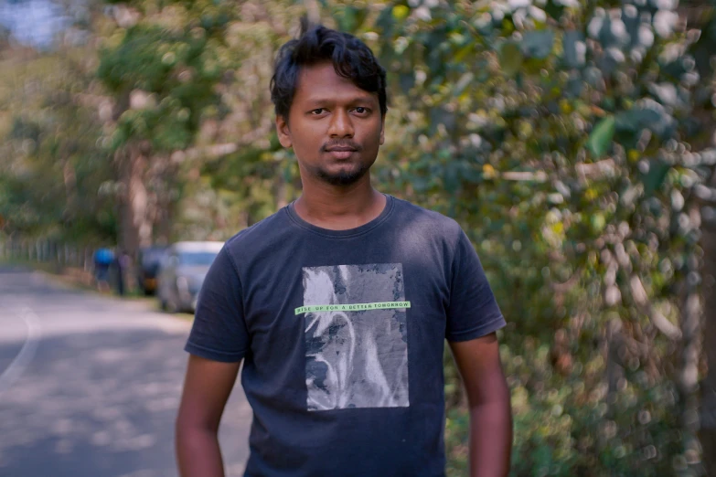 a man in a blue shirt stands by a street