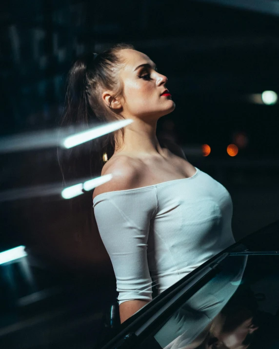 a woman wearing a white top standing near a car