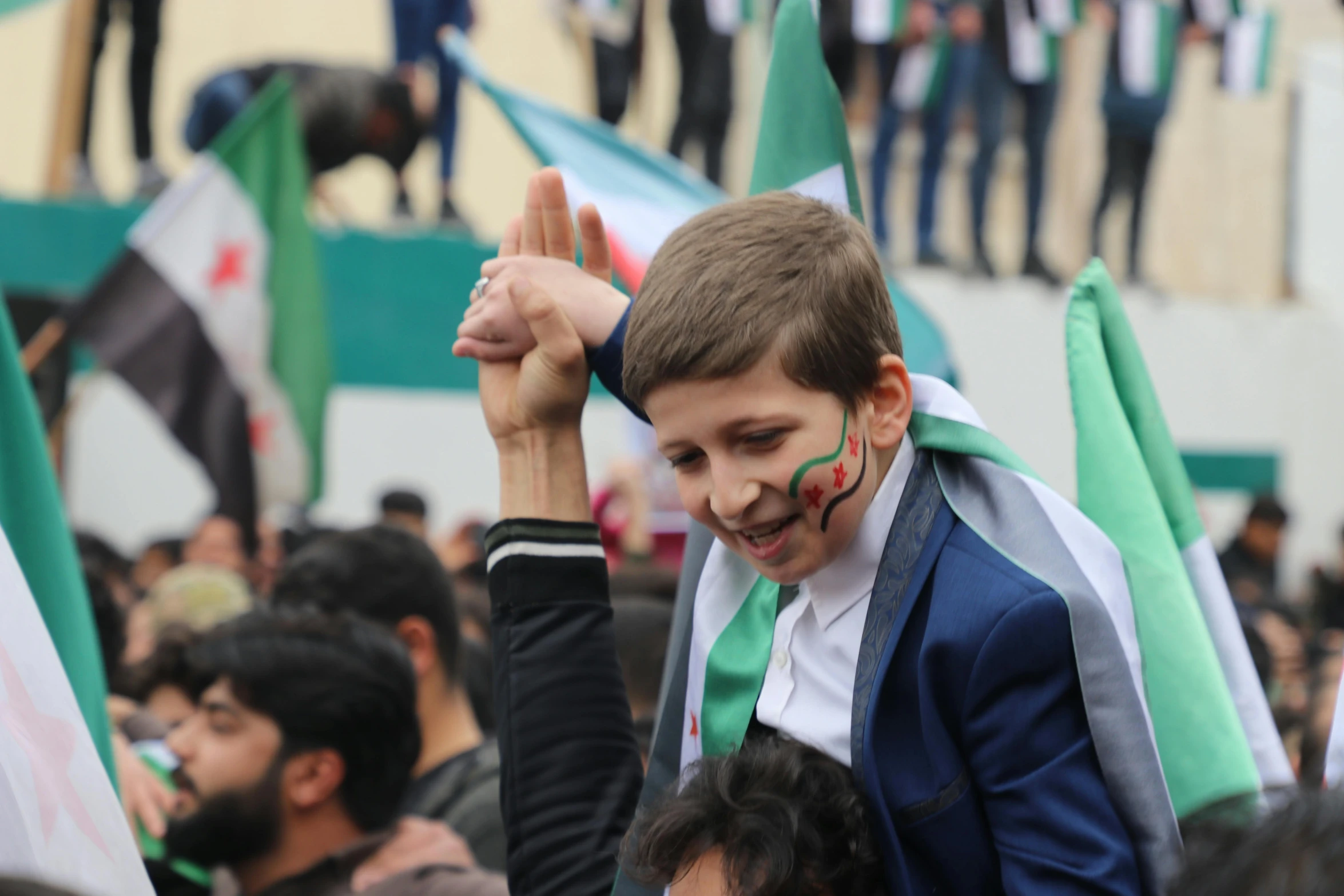 a boy in a crowd wearing a face paint