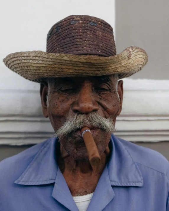 a man with a hat and a cigarette in his mouth