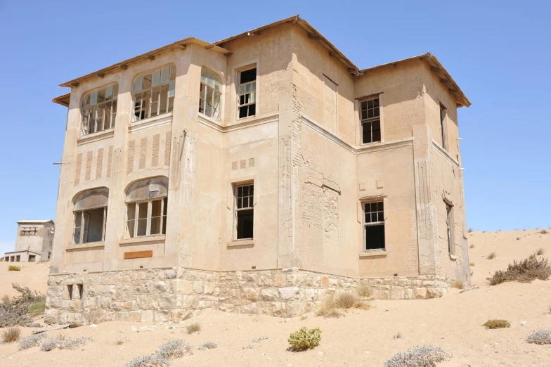 an old building sits in the middle of the desert