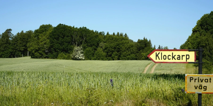 a sign is standing in a green field