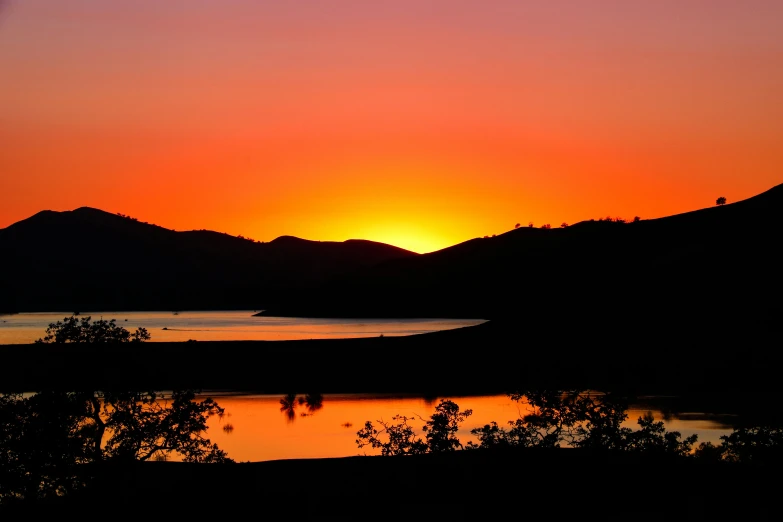 the sun is setting over a body of water