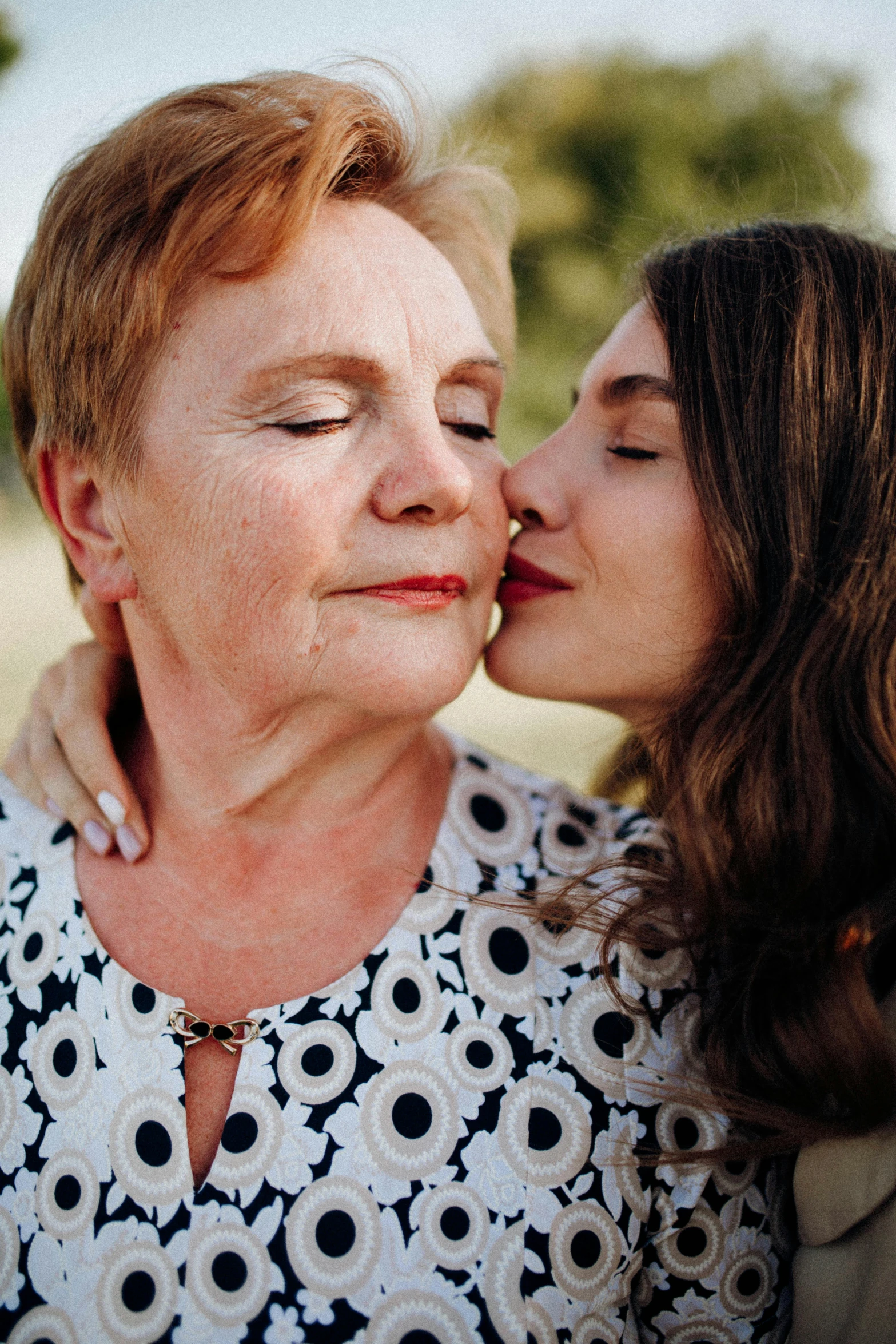 a woman kissing another woman with a smile on her face