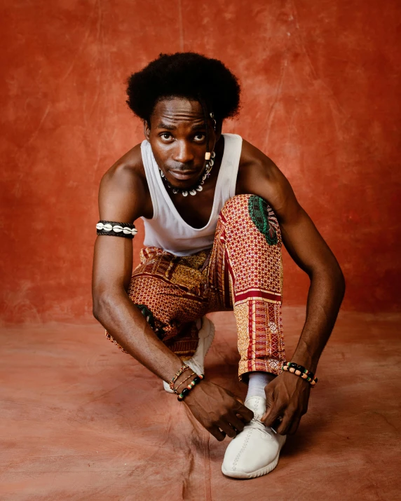 an african american man poses with a white sneaker