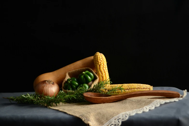 corn on the cob and other vegetables sit on a table