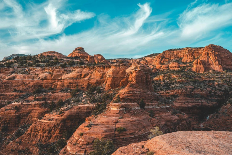 the rock formations are red and orange against the blue sky