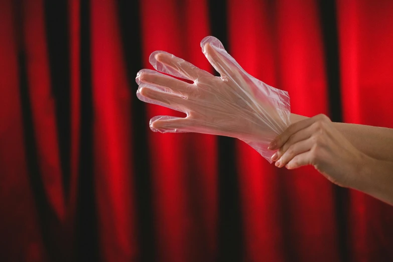 two hands are open and two in front of a red curtain