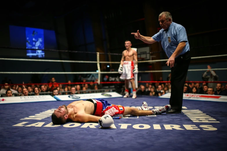 a fighter falls on the ring while his opponent talks