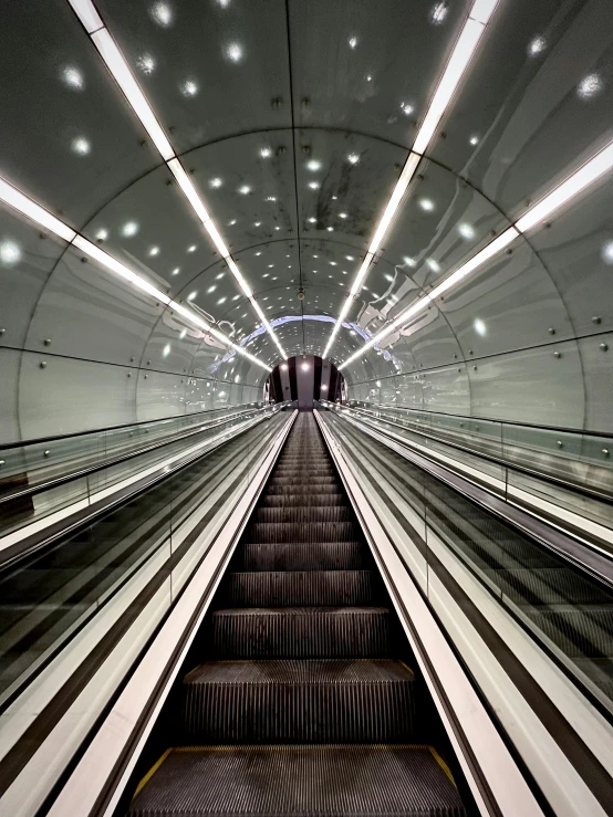 an escalator in a subway station that has its lights turned on