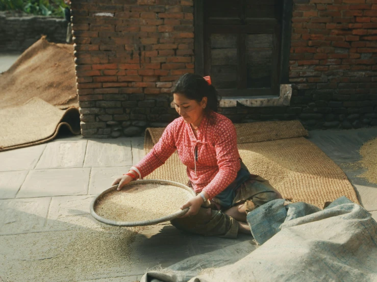 a woman sitting on the ground holding a basket