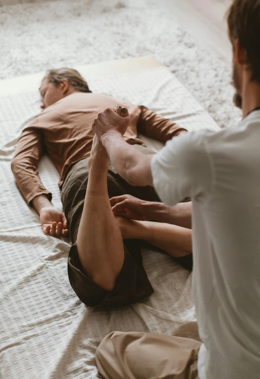 two men laying down next to each other on a bed