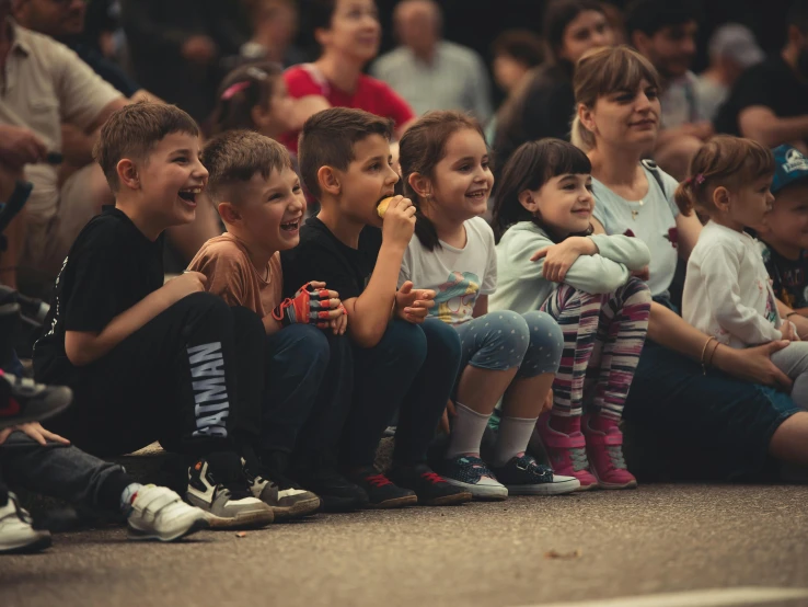 a group of children sitting in front of an audience