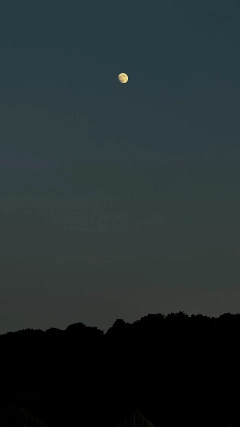 an image of moon in the sky with hills