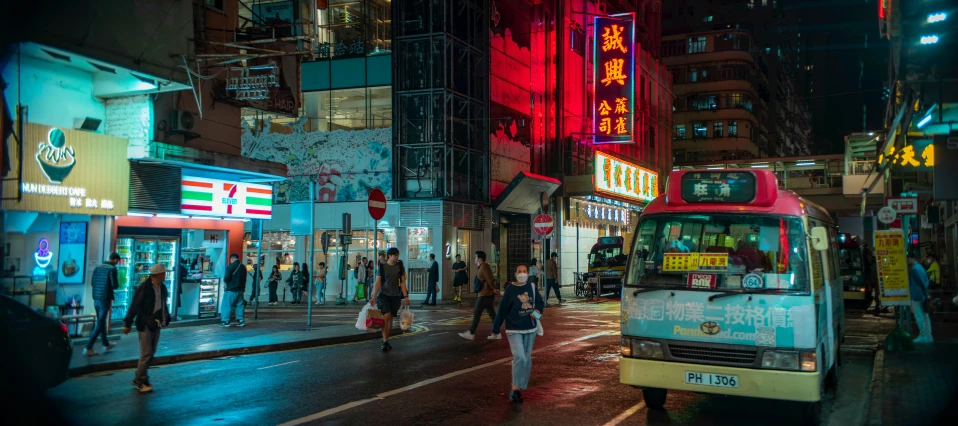 a bus driving down a street next to people walking on the side walk