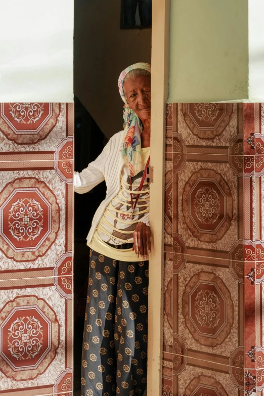 the woman wearing scarf stands at the door