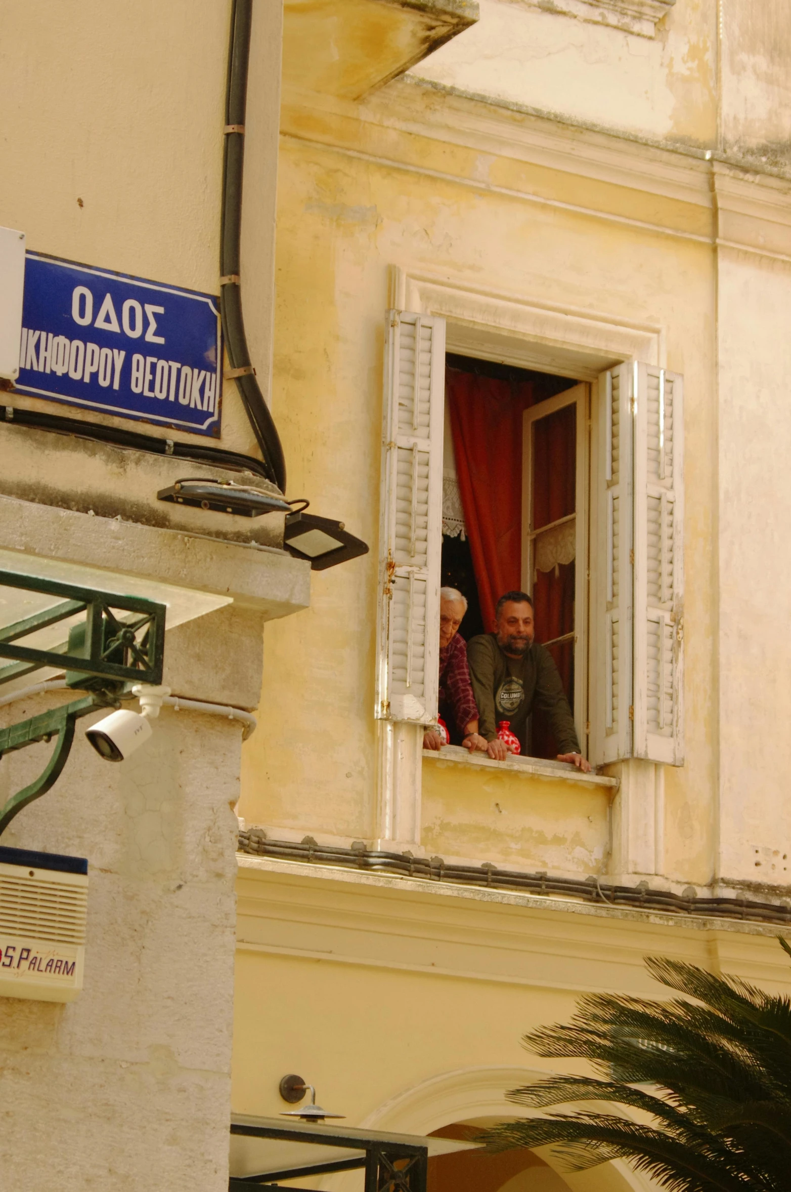 a couple are looking out the window of a building