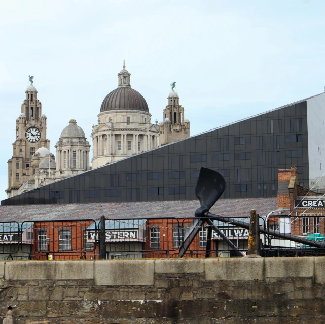 the view from the water shows a small building with domes on top and an iron roof