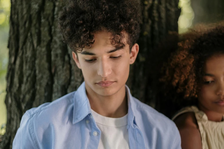 a young man looking down at a phone