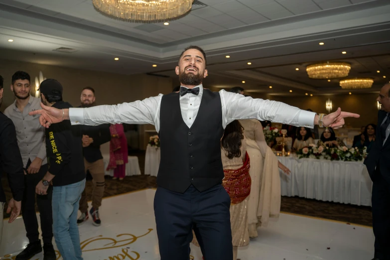 a man in tuxedo stands on the dance floor