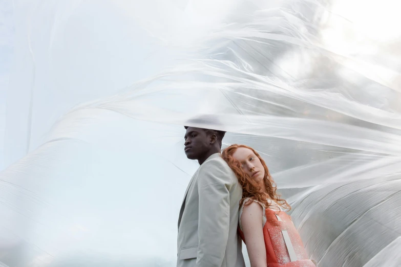 the image shows two people wearing white and wearing a red dress